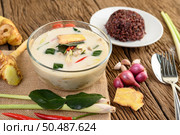 Tom Kha Kai in a bowl with kaffir lime leaves, lemongrass, red onion, galangal and chilli. Стоковое фото, агентство Ingram Publishing / Фотобанк Лори