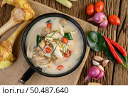 Tom Kha Kai in a pan frying with kaffir lime leaves, lemongrass, red onion, galangal and chilli. Стоковое фото, агентство Ingram Publishing / Фотобанк Лори