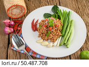 Spicy Minced Pork Salad on a white plate with lentils, kaffir lime leaves and spring onions. Стоковое фото, агентство Ingram Publishing / Фотобанк Лори