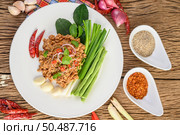 Spicy Minced Pork Salad on a white plate with red onion, lemon grass, garlic, yardlong beans, kaffir lime leaves, and spring onion. Стоковое фото, агентство Ingram Publishing / Фотобанк Лори