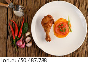 Fried chicken legs on a white plate with sauce and garlic, Shallot, chili. Стоковое фото, агентство Ingram Publishing / Фотобанк Лори