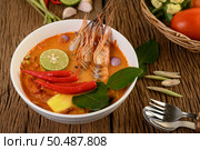 Tom Yum Kung Thai hot spicy soup shrimp with lemon grass,lemon,galangal and chilli on wooden background Thailand Food. Стоковое фото, агентство Ingram Publishing / Фотобанк Лори