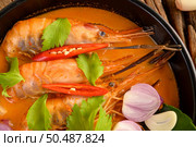 Tom Yum Kung Thai hot spicy soup shrimp with lemon grass,lemon,galangal and chilli on wooden background Thailand Food. Стоковое фото, агентство Ingram Publishing / Фотобанк Лори