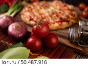 Pizza with sausage, corn, beans, shrimp and bacon on a wooden plate. Стоковое фото, агентство Ingram Publishing / Фотобанк Лори