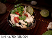 Boil the fish infusion with tomatoes, mushrooms, coriander, spring onion and lemongrass in a bowl. Стоковое фото, агентство Ingram Publishing / Фотобанк Лори