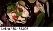 Boil the fish infusion with tomatoes, mushrooms, coriander, spring onion and lemongrass in a bowl. Стоковое фото, агентство Ingram Publishing / Фотобанк Лори