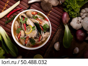 Boil the fish infusion with tomatoes, mushrooms, coriander, spring onion and lemongrass in a bowl. Стоковое фото, агентство Ingram Publishing / Фотобанк Лори