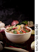 Boil the fish infusion with tomatoes, mushrooms, coriander, spring onion and lemongrass in a bowl. Стоковое фото, агентство Ingram Publishing / Фотобанк Лори