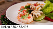 Spicy Squid and Shrimp Salad in White Dish with Lemon Cilantro and lettuce. Стоковое фото, агентство Ingram Publishing / Фотобанк Лори
