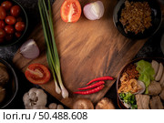Scallions, peppers, garlic, and shiitake mushrooms on a wooden plate. Стоковое фото, агентство Ingram Publishing / Фотобанк Лори