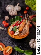 Tom Yum Kung in a bowl with tomato, chili, lemongrass, garlic, lemon, and kaffir lime leaves. Стоковое фото, агентство Ingram Publishing / Фотобанк Лори