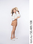 Young woman wearing a white shirt and shorts, wearing a hat and handle on the hat. Стоковое фото, агентство Ingram Publishing / Фотобанк Лори