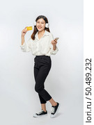 She was dressed in a white shirt and black pants to go shopping and hold a credit card and smartphone. Стоковое фото, агентство Ingram Publishing / Фотобанк Лори
