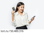 She was dressed in a white shirt and black pants to go shopping and hold a credit card and smartphone. Стоковое фото, агентство Ingram Publishing / Фотобанк Лори