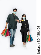 A couple of men and women wore masks and carried lots of paper bags to shop. Стоковое фото, агентство Ingram Publishing / Фотобанк Лори