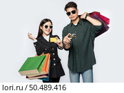 A pair of men and women wore glasses and carried lots of paper bags for shopping. Стоковое фото, агентство Ingram Publishing / Фотобанк Лори