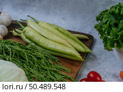 Cha-om, sweet pepper, and garlic on a wooden cutting board. Стоковое фото, агентство Ingram Publishing / Фотобанк Лори