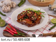 Sweet pork on a white plate with chopped scallions, chili, lime, cucumber, tomato, and garlic. Стоковое фото, агентство Ingram Publishing / Фотобанк Лори