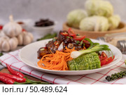 Sweet pork in a white plate with chopped scallions, chili, lime, gourd, tomato and garlic. Стоковое фото, агентство Ingram Publishing / Фотобанк Лори