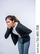 A woman with a stomachache puts her hands on her stomach and covers her mouth. Стоковое фото, агентство Ingram Publishing / Фотобанк Лори