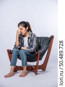 The woman was sick, sat on a chair, and touched her head with her hand. Стоковое фото, агентство Ingram Publishing / Фотобанк Лори