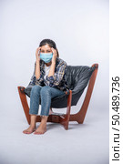 The woman was sick, sat on a chair, and touched her head with her hand. Стоковое фото, агентство Ingram Publishing / Фотобанк Лори