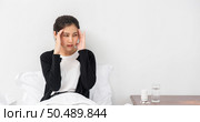 The sick woman had a headache and the hands touched her head on the bed. Стоковое фото, агентство Ingram Publishing / Фотобанк Лори