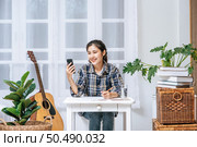 Women sit at the desk and use the phone to coordinate. Стоковое фото, агентство Ingram Publishing / Фотобанк Лори