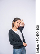 Girl in white stretch jeans and do hand prohibition sign on white background. Стоковое фото, агентство Ingram Publishing / Фотобанк Лори