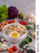 Boiled egg porridge in a white cup and sprinkled with sliced ??spring onions. Стоковое фото, агентство Ingram Publishing / Фотобанк Лори