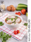 Squid soup stuffed with pork, sprinkled with coriander and chopped scallions in white cups. Стоковое фото, агентство Ingram Publishing / Фотобанк Лори