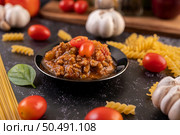 Sauce for stir-frying spaghetti or stir-frying macaroni on a black plate. Стоковое фото, агентство Ingram Publishing / Фотобанк Лори