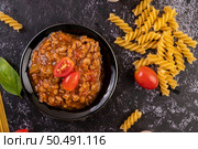 Sauce for stir-frying spaghetti or stir-frying macaroni on a black plate. Стоковое фото, агентство Ingram Publishing / Фотобанк Лори