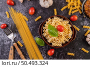 Macaroni sauteed with tomatoes and basil on a gray plate. Стоковое фото, агентство Ingram Publishing / Фотобанк Лори