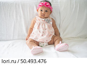 A baby learns to sit on a white bed. Стоковое фото, агентство Ingram Publishing / Фотобанк Лори