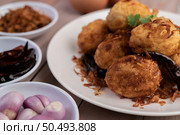 Boiled eggs stir-fried with tamarind sauce, topped with fried onions and dried chilies, son-in-law, Thai food. Стоковое фото, агентство Ingram Publishing / Фотобанк Лори