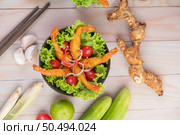 Shrimp deep fried batter placed on salad and tomatoes in a wooden bowl. Стоковое фото, агентство Ingram Publishing / Фотобанк Лори