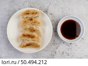 Gyoza beautifully arranged in a white plate with sauce. Стоковое фото, агентство Ingram Publishing / Фотобанк Лори