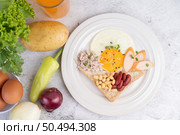 Breakfast consists of fried eggs, sausage, minced pork, bread, red beans and soy on a white plate. Стоковое фото, агентство Ingram Publishing / Фотобанк Лори