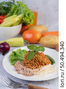 Stir-fried noodles with minced pork, edamame, tomatoes and mushrooms in a white plate. Стоковое фото, агентство Ingram Publishing / Фотобанк Лори