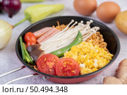 Stir fried noodle that combines corn, golden needle mushroom, tomato, sausage, edamame and spring onions in a frying pan. Стоковое фото, агентство Ingram Publishing / Фотобанк Лори