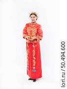 Woman wear Cheongsam suit with crown give gold to her relative for lucky in chinese new year. Стоковое фото, агентство Ingram Publishing / Фотобанк Лори
