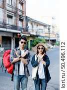 Young backpacker couple in sunglasses make a prohibition cross mark with both hands express negative attitude coronavirus don’t close contact while travel in city street On City Street. Стоковое фото, агентство Ingram Publishing / Фотобанк Лори