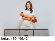 Portrait happy young pretty woman in apron and rubber gloves holding a spray bottle with cloth preparing to cleaning, smile and looking to camera, copy space. Стоковое фото, агентство Ingram Publishing / Фотобанк Лори