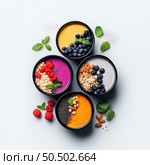 Various fresh smoothies displayed in colorful bowls with vibrant fruits. Стоковое AI-изображение, AI-художник Татьяна  Бральнина / Фотобанк Лори