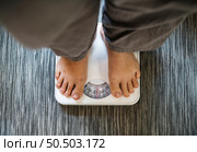 Woman standing on a scale. Стоковое фото, агентство Ingram Publishing / Фотобанк Лори