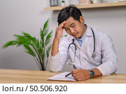 The doctor sat in the room where he worked with stress. Стоковое фото, агентство Ingram Publishing / Фотобанк Лори