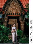 Portrait Asian charming woman wearing beautiful typical Thai dress identity culture of Thailand in ancient temple or famous place with gracefully pose, copy space. Стоковое фото, агентство Ingram Publishing / Фотобанк Лори