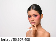 The woman put on pink makeup and put her hand on her chin. Isolated on white background. Стоковое фото, агентство Ingram Publishing / Фотобанк Лори