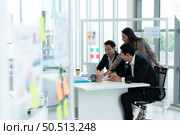 Young entrepreneurs in Asia Organize meetings to brainstorm and review information on glass board to get the best investment conclusion. Стоковое фото, агентство Ingram Publishing / Фотобанк Лори